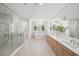 Large bathroom with marble shower, soaking tub, dual sinks and luxurious fixtures at 619 Key Royale Dr, Holmes Beach, FL 34217