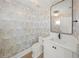 Elegant half bath featuring jellyfish wallpaper, a stylish mirror, and a modern sink at 619 Key Royale Dr, Holmes Beach, FL 34217