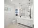 White bathroom with marble tile floor, single sink vanity, and nautical art at 619 Key Royale Dr, Holmes Beach, FL 34217