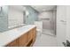 Modern bathroom featuring a glass shower, tile accent wall, and wood vanity with light countertops at 619 Key Royale Dr, Holmes Beach, FL 34217