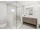 Stylish bathroom with a glass shower, neutral tiles, and a wood-grain vanity with sleek hardware at 619 Key Royale Dr, Holmes Beach, FL 34217