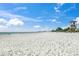 A sunny beach with a lifeguard tower and beachgoers in the distance at 619 Key Royale Dr, Holmes Beach, FL 34217