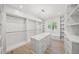Spacious walk-in closet featuring custom shelving, large center island and chandelier lighting at 619 Key Royale Dr, Holmes Beach, FL 34217