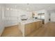 Bright kitchen with custom white cabinets, a large island, and stainless steel appliances at 619 Key Royale Dr, Holmes Beach, FL 34217