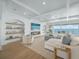 Coastal living room with ocean views, a fireplace, and elegant built-in shelving at 619 Key Royale Dr, Holmes Beach, FL 34217