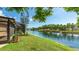 Picturesque backyard view overlooking a serene lake, framed by lush greenery and mature trees at 620 49Th E St, Bradenton, FL 34208