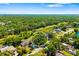Aerial view of the home surrounded by lush greenery and mature trees in a quiet neighborhood at 7158 S Leewynn Dr, Sarasota, FL 34240