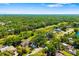Aerial view of the home surrounded by lush greenery and mature trees in a quiet neighborhood at 7158 S Leewynn Dr, Sarasota, FL 34240