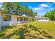 A well-maintained backyard with lush green grass, a cozy sunroom, and partial views of the main house at 7158 S Leewynn Dr, Sarasota, FL 34240