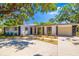 Charming single-story home with mature trees, neutral tones, front yard landscaping, and an attached two-car garage at 7158 S Leewynn Dr, Sarasota, FL 34240