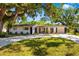 Charming single-story home with mature trees, well-manicured lawn, and a long driveway at 7158 S Leewynn Dr, Sarasota, FL 34240