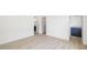 Bright hallway with white walls and light wood floors with a glimpse into a bathroom with a dark vanity at 7158 S Leewynn Dr, Sarasota, FL 34240
