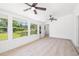 Bright living room features a wall of windows that lets in natural light and has beautiful, light wood floors at 7158 S Leewynn Dr, Sarasota, FL 34240