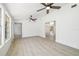 Large living room features light wood floors, white walls, and multiple ceiling fans, providing lots of space at 7158 S Leewynn Dr, Sarasota, FL 34240