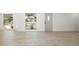 Bright living room with large windows and a decorative front door plus light wood floors and white walls at 7158 S Leewynn Dr, Sarasota, FL 34240