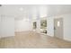 Large living room with bright white walls, light wood floors, and large windows plus a decorative door at 7158 S Leewynn Dr, Sarasota, FL 34240