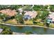 Aerial view of home, screened lanai, pool, well-maintained lawn, and water view at 7319 Westminster Ct, University Park, FL 34201