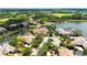 Panoramic aerial view showcases a home with a tile roof, pool, landscaping, and golf course beyond the lake at 7319 Westminster Ct, University Park, FL 34201