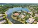Aerial view of home with tile roof, pool, surrounded by lush greenery and a winding canal at 7319 Westminster Ct, University Park, FL 34201