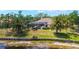 Lovely backyard with a screened-in lanai, swimming pool, mature trees, and waterfront views at 7319 Westminster Ct, University Park, FL 34201