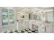 Bright bathroom featuring a double vanity, a large mirror and black and white floors at 7319 Westminster Ct, University Park, FL 34201