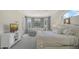 Bright bedroom with white furniture, light carpet, a sitting area, and natural light from the windows at 7319 Westminster Ct, University Park, FL 34201