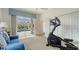 Bright exercise room with neutral carpet, blue sofa, and sliding glass doors leading to a screened lanai with a pool at 7319 Westminster Ct, University Park, FL 34201