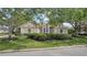 Charming cream-colored home with a well-maintained lawn, mature trees and manicured hedges at 7319 Westminster Ct, University Park, FL 34201