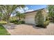 Charming home exterior featuring a brick driveway, lush landscaping, and a two-car garage at 7319 Westminster Ct, University Park, FL 34201