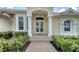 Elegant front entrance features decorative glass doors, arched columns, and manicured landscaping at 7319 Westminster Ct, University Park, FL 34201