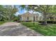 Elegant home exterior with a lush green lawn and a paver driveway leading to the front entrance at 7319 Westminster Ct, University Park, FL 34201