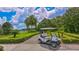 Golf cart parked on a paved path with a scenic view of the golf course and lake at 7319 Westminster Ct, University Park, FL 34201