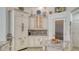 Bright kitchen featuring a granite countertop, white cabinets, stainless steel appliances, and a tiled floor at 7319 Westminster Ct, University Park, FL 34201