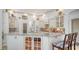 Bright kitchen featuring a large island, granite countertops, and white cabinetry with glass displays at 7319 Westminster Ct, University Park, FL 34201