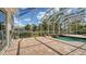 Spacious screened-in pool area with brick pavers, a tranquil waterfall feature, and lush landscaping for ultimate relaxation at 7319 Westminster Ct, University Park, FL 34201