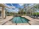 Stunning screened pool area with brick pavers, a serene waterfall feature, and comfortable lounge chairs for relaxation at 7319 Westminster Ct, University Park, FL 34201