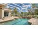Beautiful screened pool area with brick pavers, a gentle waterfall, and a serene view of the surrounding landscape at 7319 Westminster Ct, University Park, FL 34201