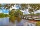 Scenic view of a wooden bridge over a lake, surrounded by lush greenery and mature trees at 7319 Westminster Ct, University Park, FL 34201