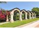 Inviting arbor with flowering vines and lush greenery overlooking a tranquil lake at 8263 Nice Way, Sarasota, FL 34238