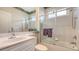 Bright bathroom featuring tiled walls, glass shower doors, and a large mirror at 8263 Nice Way, Sarasota, FL 34238