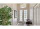 Bright foyer with double glass doors and elegant decor creating a welcoming entrance at 8263 Nice Way, Sarasota, FL 34238