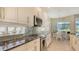 Kitchen featuring granite countertops, stainless-steel appliances, and bar seating at 8263 Nice Way, Sarasota, FL 34238