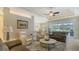 Inviting living room featuring comfortable seating, a ceiling fan, and serene views of the outdoors at 8263 Nice Way, Sarasota, FL 34238