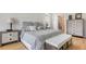 Comfortable main bedroom featuring a large upholstered headboard, a bench, and stylish furnishings at 8263 Nice Way, Sarasota, FL 34238