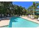 Inviting community pool with ample lounge seating and mature trees at 8263 Nice Way, Sarasota, FL 34238
