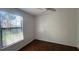 Bright bedroom with hardwood floors, ceiling fan, and a large window overlooking green outdoor scenery at 8325 38Th Street E Cir # 101, Sarasota, FL 34243