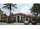 Clubhouse featuring manicured landscaping, tile roof, and parking at 8325 38Th Street E Cir # 101, Sarasota, FL 34243