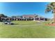 View of the clubhouse exterior showcasing its large windows, landscaping, and golf carts on a sunny day at 9630 Club South Cir # 6204, Sarasota, FL 34238