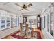 Bright dining room featuring a glass table, decorative ceiling fan, and large windows at 10315 Cortez W Rd # 24H, Bradenton, FL 34210