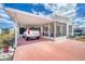 Inviting single-story home featuring a convenient carport, screened porch, and pink driveway at 10315 Cortez W Rd # 24H, Bradenton, FL 34210